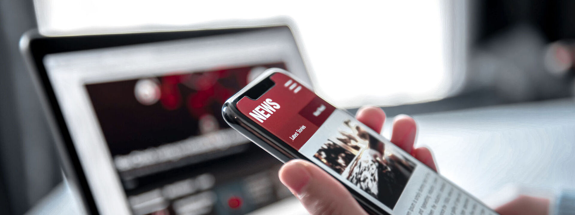 Ein Smartphone mit einem Laptop im Hintergrund